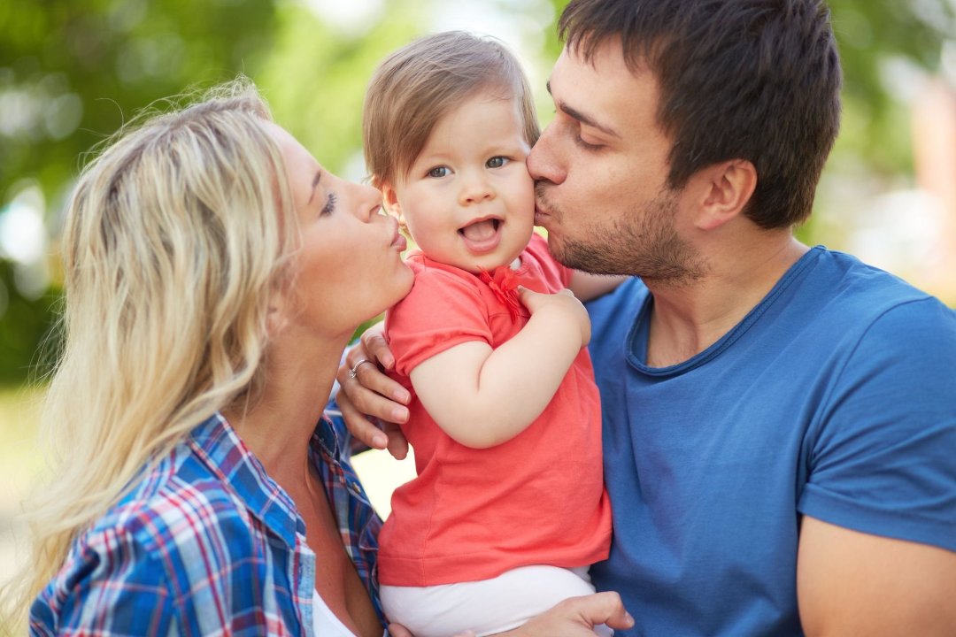 happy_parents_kissing_their_child_-_family_law_in_gulf_breeze_-_lacie_bowden_law.jpg