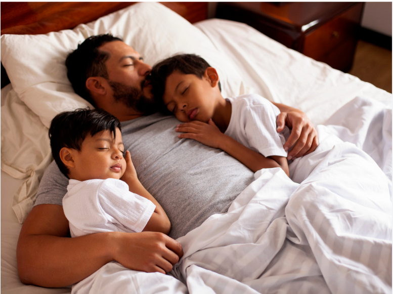 father_sleeping_with_sons_in_bed-_lacie_bowden_law.png
